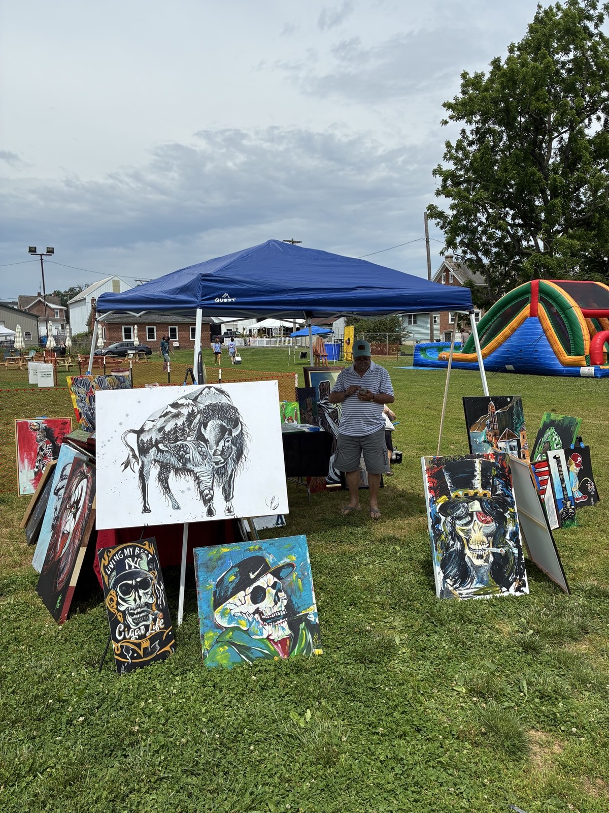 Franco Piperis at his outdoor art fair tent with his paintings on display